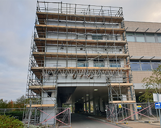 large commercial structure completely clad in scaffolding