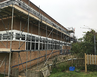 commercial building with two scaffolding catwalks encompassing it
