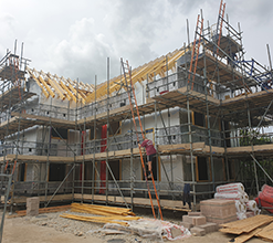 new home construction with wall cladding and scaffolding