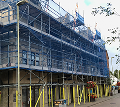 street-side scaffolding with yellow foam buffers on scaffolding
