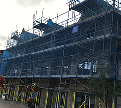 public street-side building scaffolding with blue netting