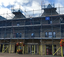 commercial building featuring scaffolding catwalks and blue safety netting